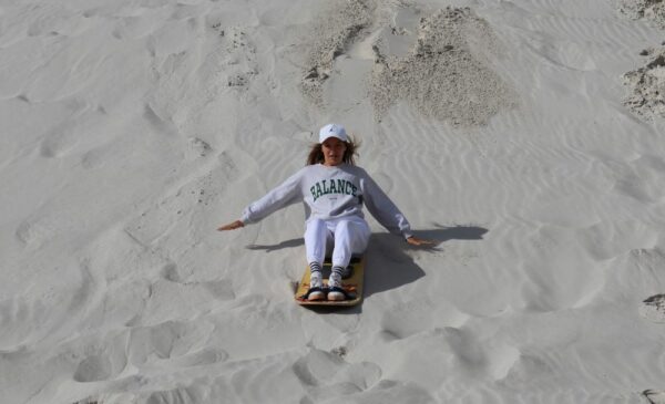 A person enjoying sandboarding at WILD X Adventures at The Atlantis Dunes