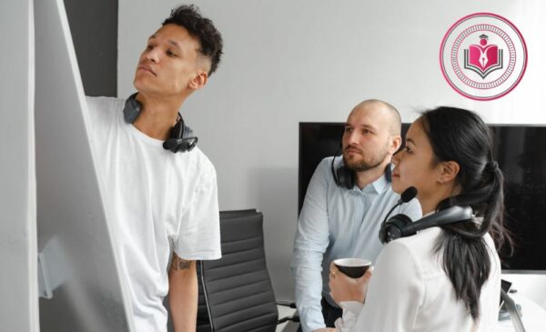 Three people huddled around a whiteboard