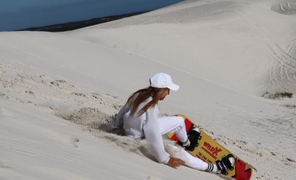 A woman trying ultimate sandboarding at Wild X Adventures at the Atlantis Dunes