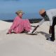 A woman being assisted whilst trying ultimate sandboarding at Wild X Adventures at the Atlantis Dunes
