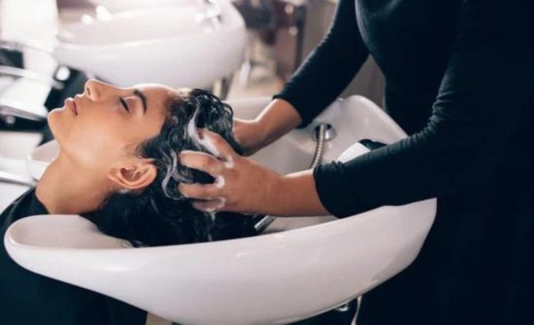 A stock photo of a woman getting her hair washed at a hair salon