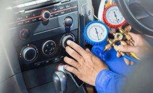 A stock photo of a professional re-gassing a car aircon