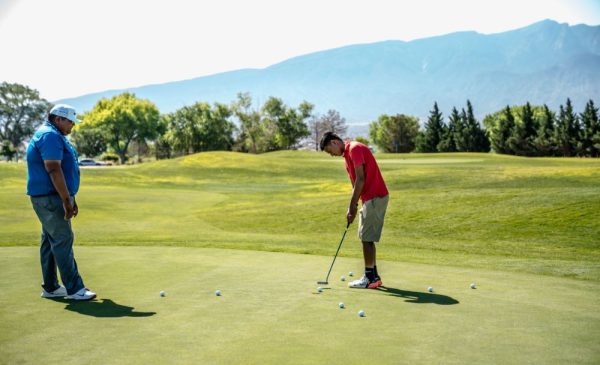 A stock photo of two men playing golf on a golf course